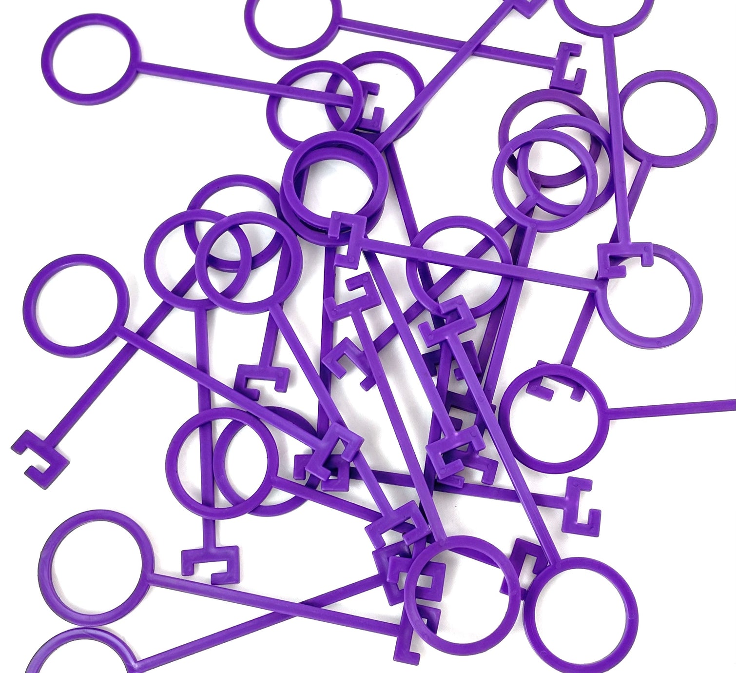 A scattered pile of Yankee Thunder's Purple Clay Pigeon Hooks, made from durable polymer material and featuring circular loops at one end, against a white background.